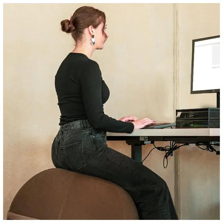 Eine Frau sitzt auf dem Viva Ball